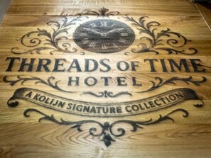 A wooden sign with the text "Threads of Time Hotel" and "A Kolijn Signature Collection". -  Lovelace Suites by Threads of Time Hotel Bruges (Bruges)
