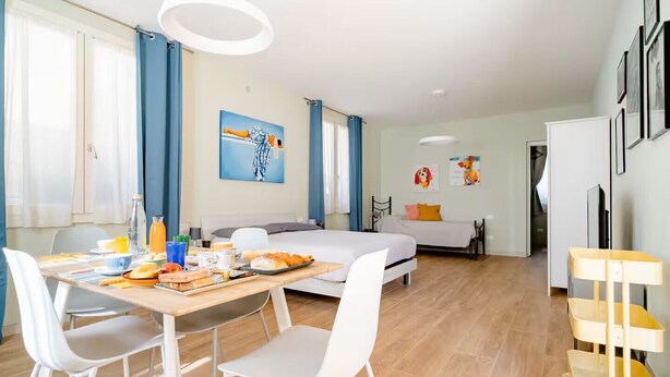 Une chambre d’hôtel moderne comprenant un coin repas, un lit et une kitchenette.