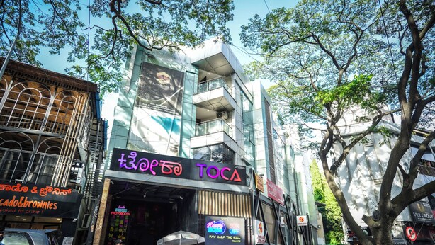 A multi-story building with a prominent 'TOCA' sign. - Santrina Hotels (Bengaluru)
