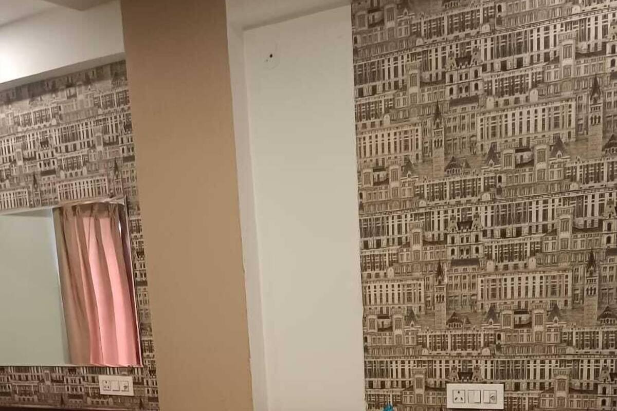 A hotel room with a large bed, a desk, and a mirror.