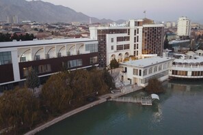 Un edificio moderno con un letrero que dice 'Parliament', situado cerca de una masa de agua con un puente y un muelle.