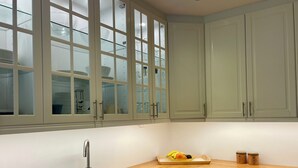 Een keuken met een dubbele spoelbak, een houten aanrechtblad en lichte kastjes.