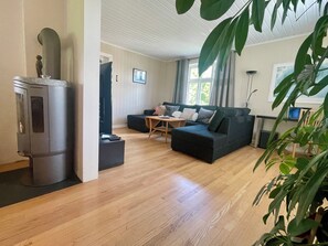 A modern living room with a sectional sofa, a coffee table, and a fireplace.