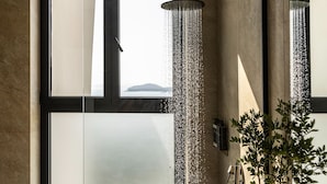 Uma casa de banho moderna com uma janela grande, um chuveiro e uma planta em vaso.