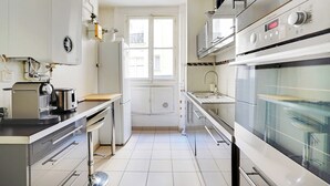 A modern kitchen with a built-in oven, a microwave, and a toaster. - Charming Apartment- 2br-4p- Parc Monceau (Paris)