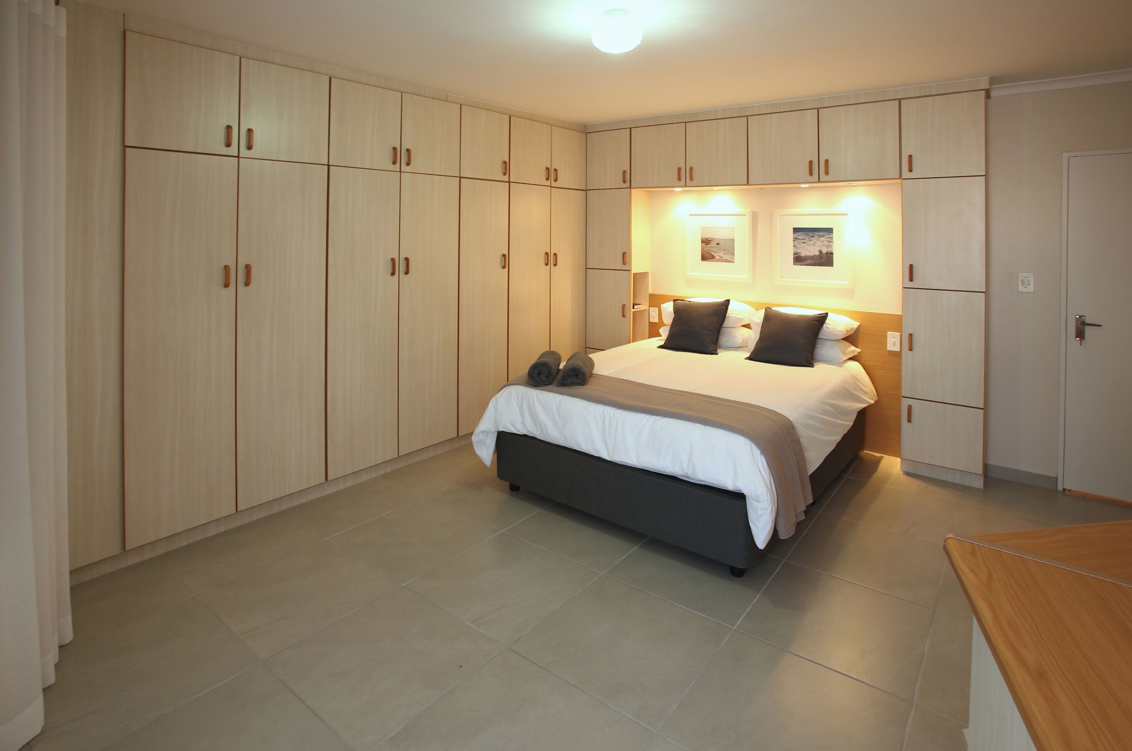 A bedroom with a bed, a wardrobe, and a nightstand.
