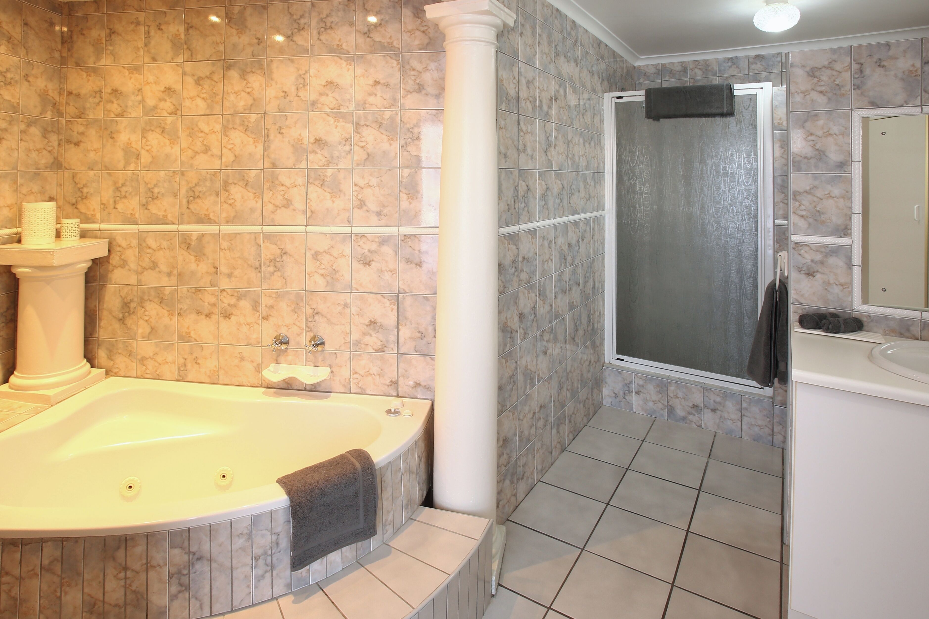 A bathroom with a large bathtub, a shower, and a sink.