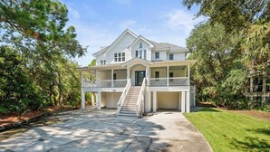 A two-story house with a front porch, a staircase, and a well-maintained lawn. - 723 Seahorse Road (Fripp Island)