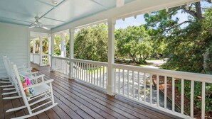 A covered porch with white railings, wooden flooring, and rocking chairs. - 723 Seahorse Road (Fripp Island)