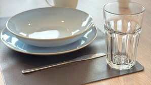 A dining table with plates, a glass, and a spoon. - Modern Flat | washing machine, underfloor heating, rain shower (karlsruhe)