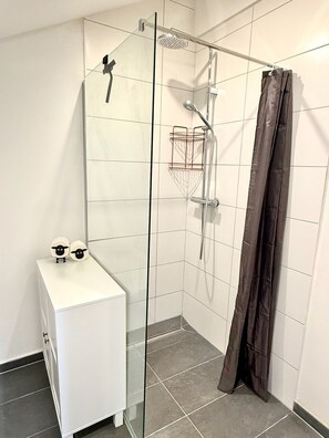 Een douche, een haardroger, handdoeken, toiletpapier