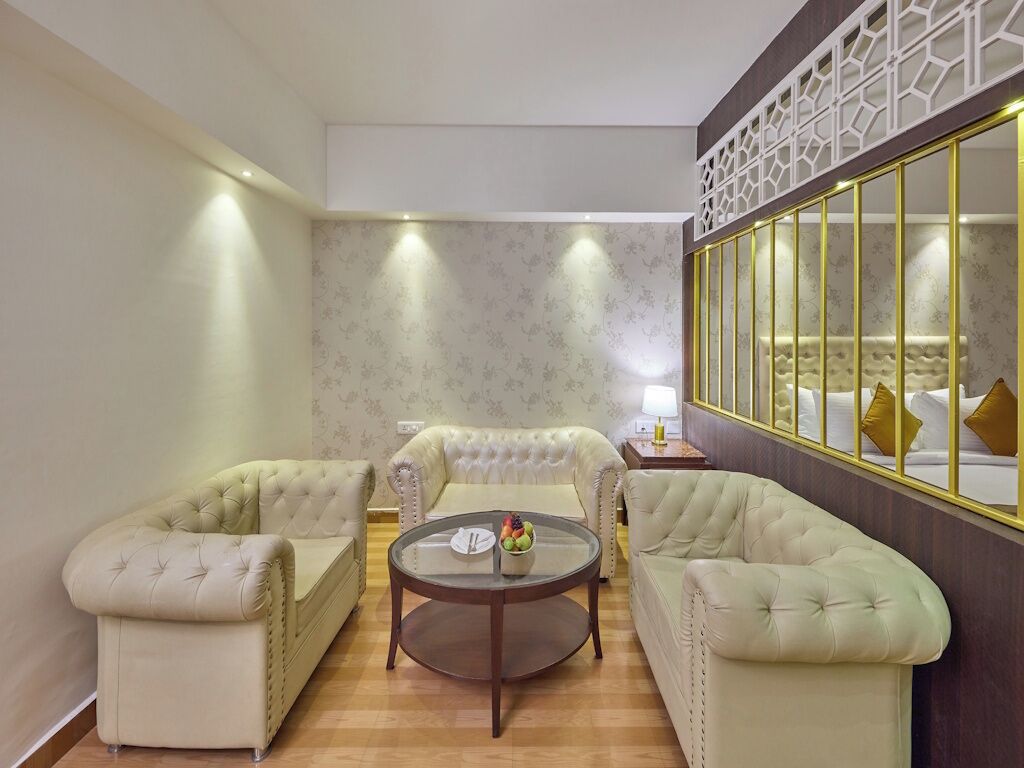 A room with a sofa set, a round coffee table, and a decorative mirror.