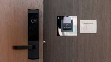 A modern door with a digital lock and a keyhole, a wall socket, and a door handle.