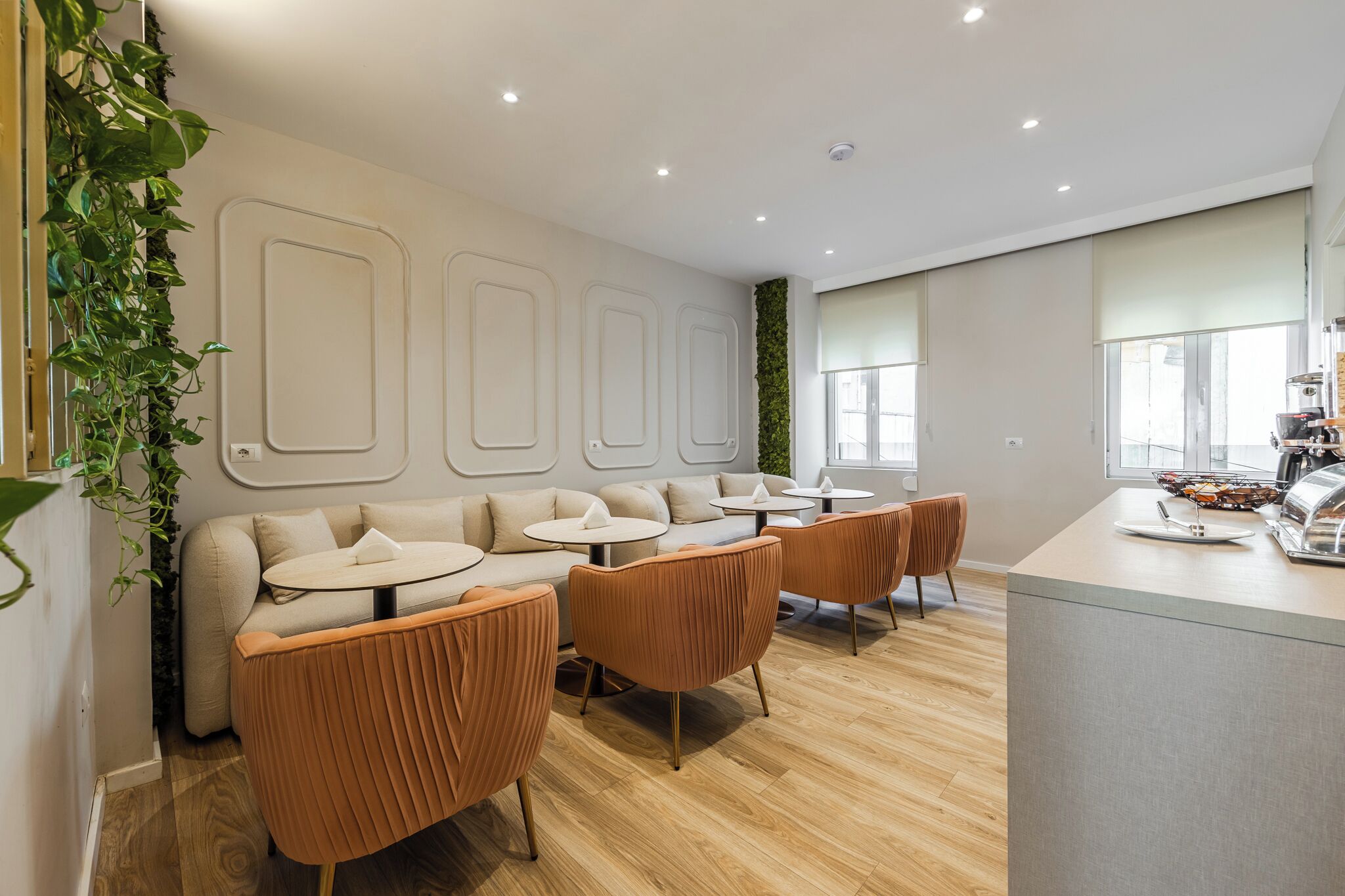 A modern interior with a sofa, round tables, and a bar area.