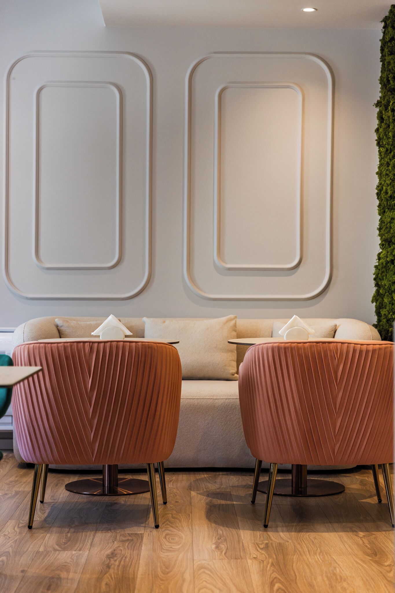 Un interior moderno con un sofá, dos sillones a juego, una mesita y paneles decorativos en la pared.