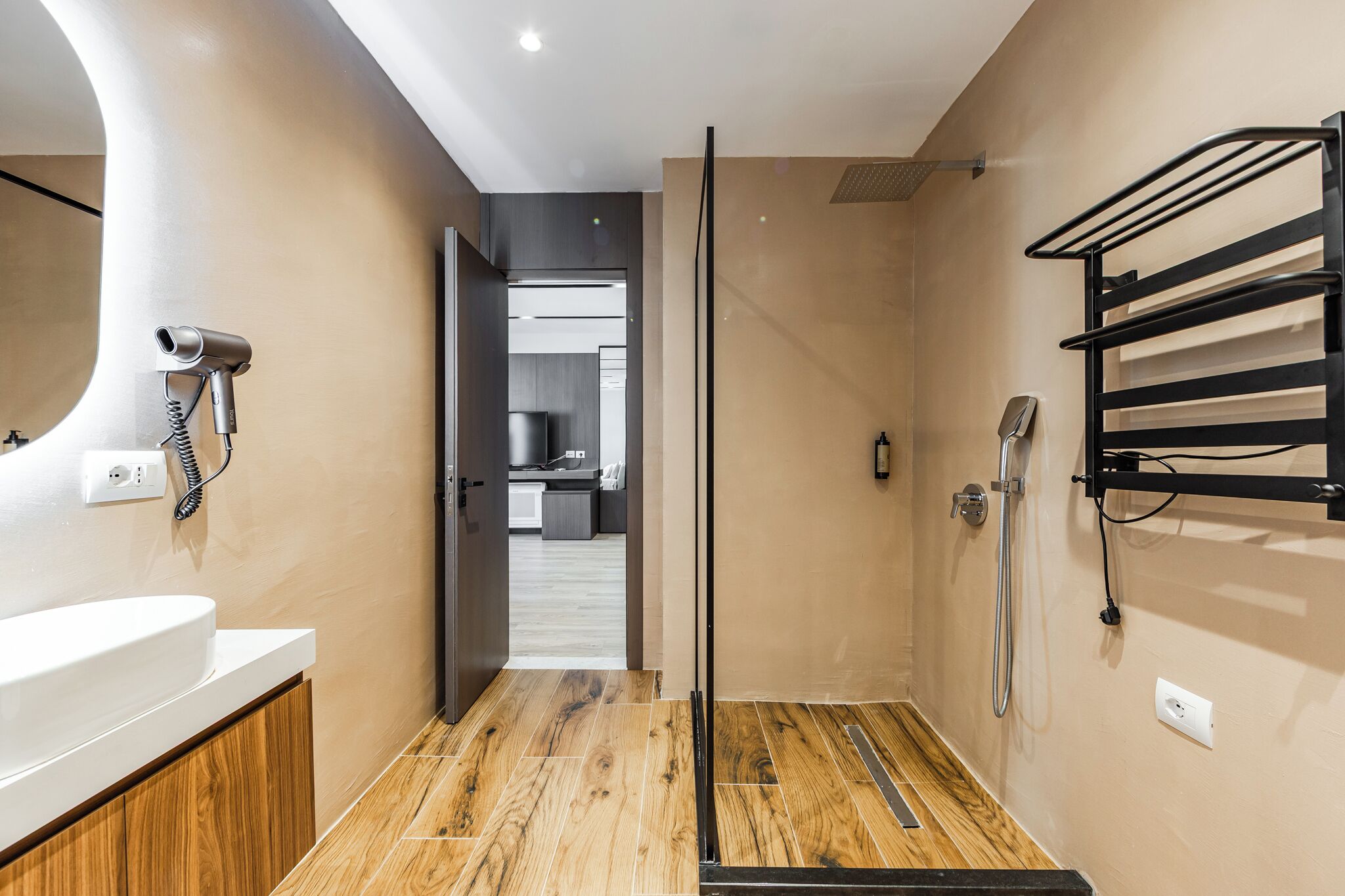 Ein modernes Badezimmer mit Dusche, Föhn und Handtuchhalter.