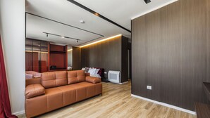 A modern living room with a sofa, a television, and a wooden floor. - Hotel Aquila D (Durrës)