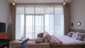 Ein Hotelzimmer mit einem großen Bett, einem Schreibtisch, einem Sessel und einem Fernseher.