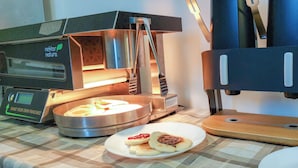 A kitchen with a toaster, a bread box, and a plate with toast and jam. - Milada (Prague)