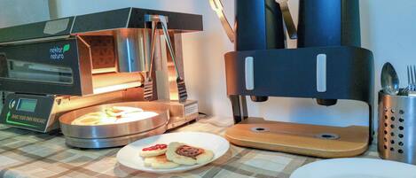 A kitchen with a toaster, a bread box, and a plate with toast and jam.
