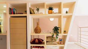 A multi-tiered bookshelf with decorative items and a 'Smile' sign.