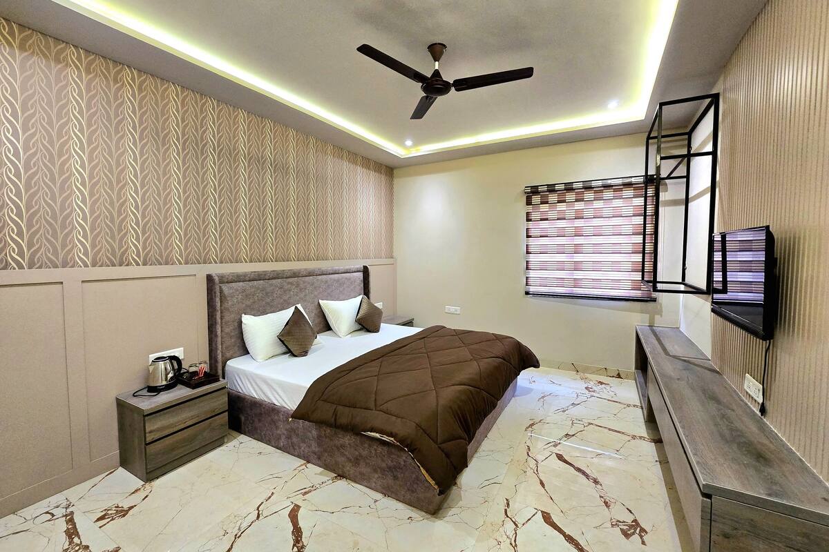Un dormitorio con cama, mesita de noche y ventilador de techo.