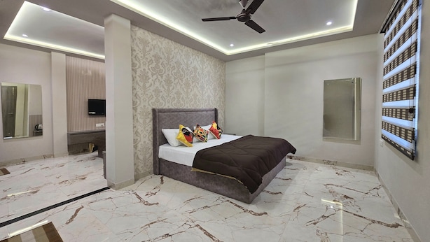Een moderne slaapkamer met een bed, plafondventilator en marmeren vloer.