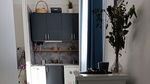 A kitchen with dark cabinets, a refrigerator, and a dining area with a table and chairs.