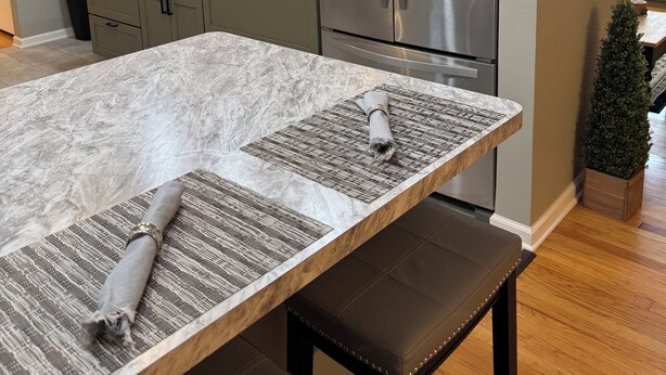 A modern kitchen with a stainless steel refrigerator, a marble countertop, and a bench. - Cherry Tree Vacation Home, 4 BR 2 BA 2500 sq ft, safe neighborhood .9 mi to ND! (South Bend)