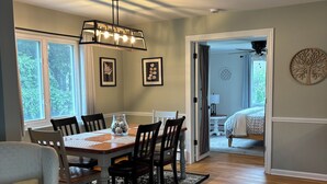 A dining area with a wooden table and chairs, a chandelier, and framed artwork on the walls. - Cherry Tree Vacation Home, 4 BR 2 BA 2500 sq ft, safe neighborhood .9 mi to ND! (South Bend)