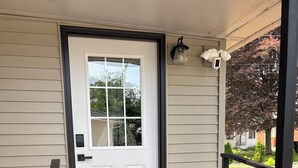 A front door with a doormat, a mailbox, and a small porch area with a bench and a trash can. - Cherry Tree Vacation Home, 4 BR 2 BA 2500 sq ft, safe neighborhood .9 mi to ND! (South Bend)