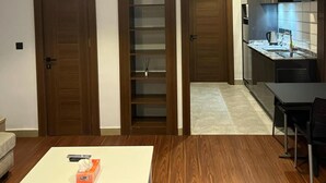 A modern interior with a dining area, a kitchen, and a hallway. - Moz One Apartments (Abuja)
