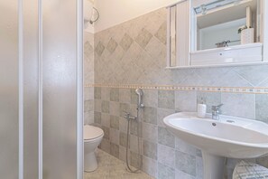 Ein Badezimmer mit Toilette, Dusche und Waschbecken.