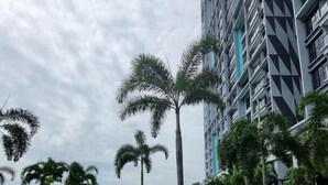 A modern building with a geometric facade, surrounded by a landscaped area with palm trees and a central water feature. - Trion Hotel Suites By Havenza (Kuala Lumpur)