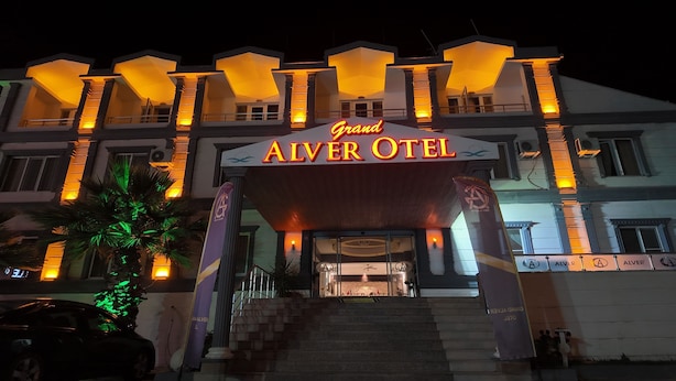 The Grand Alver Hotel entrance with a prominent sign, steps leading up to the entrance, and a palm tree to the left. - GRAND ALVER OTEL (Edremit)