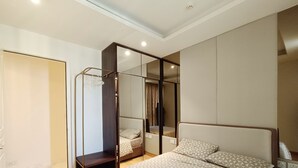 Un dormitorio moderno con una cama grande, un armario y un espejo.
