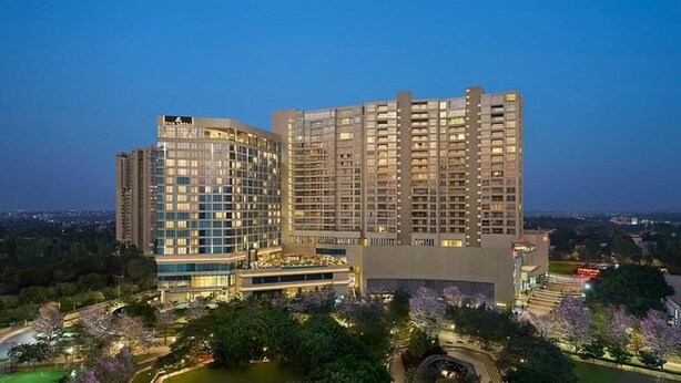 Un hotel de varios pisos con un diseño moderno, que combina fachadas de vidrio y concreto.