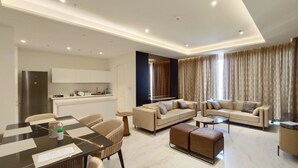 Una sala de estar moderna con un conjunto de sofá, una mesa de comedor y una zona de cocina.