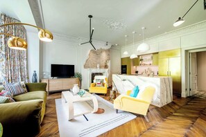 A modern living room with a sofa, armchair, coffee table, and a fireplace.