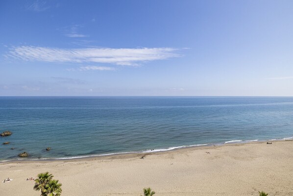 Una playa con cielos despejados y aguas tranquilas.