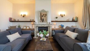 A living room with two sofas, a fireplace, and decorative wall sconces. -  A Vintage Jewel with Panoramic Lake Views (Argegno)