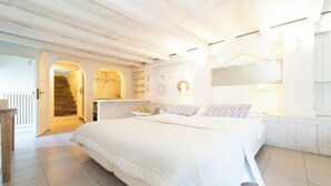 A bedroom with a large bed, a wooden ceiling, and a built-in bench. -  A Vintage Jewel with Panoramic Lake Views (Argegno)