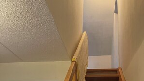 Eine Holztreppe mit Geländer und einem weißen Stoff darüber.