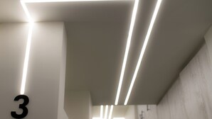 Un intérieur moderne agrémenté d’un luminaire aux formes géométriques et d’un chiffre « 3 » bien visible sur le mur.