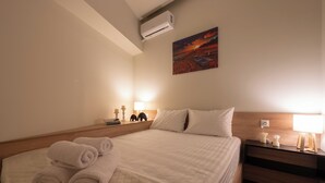 Une chambre d’hôtel avec un grand lit, une table de chevet avec une lampe et un tableau au mur.