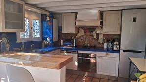 Eine Küche mit Holzarbeitsplatte, Spüle, Herd und Kühlschrank.