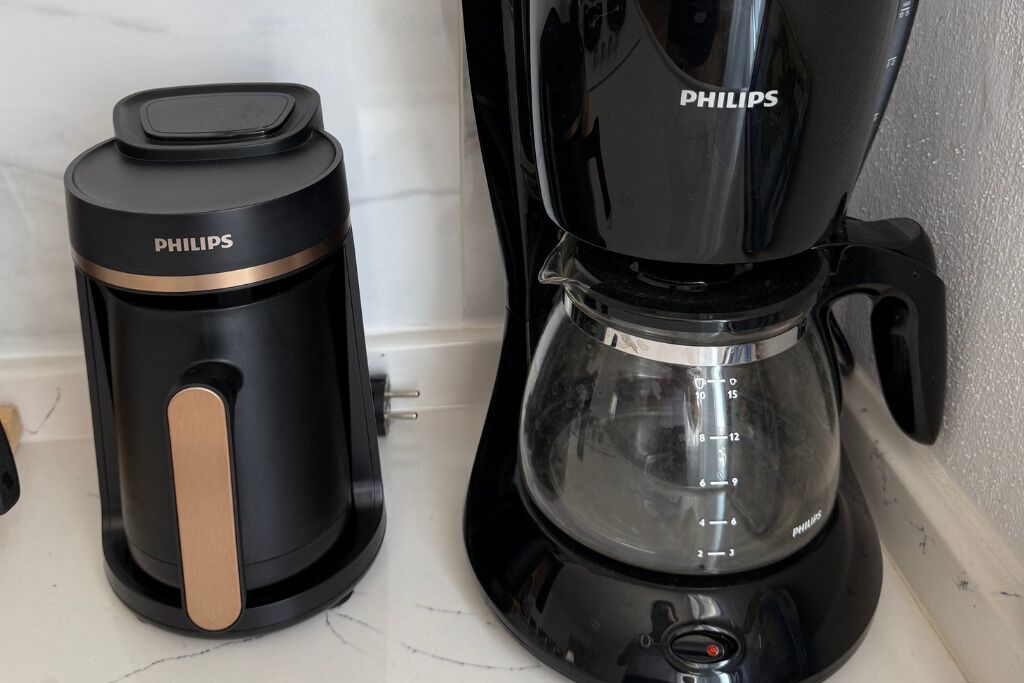 Una caffettiera nera con caraffa in vetro e thermos nero.