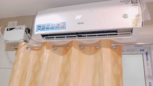An air conditioner with a digital display, a remote control, and a brand name 'elista'. - GM Residency (Velankanni)