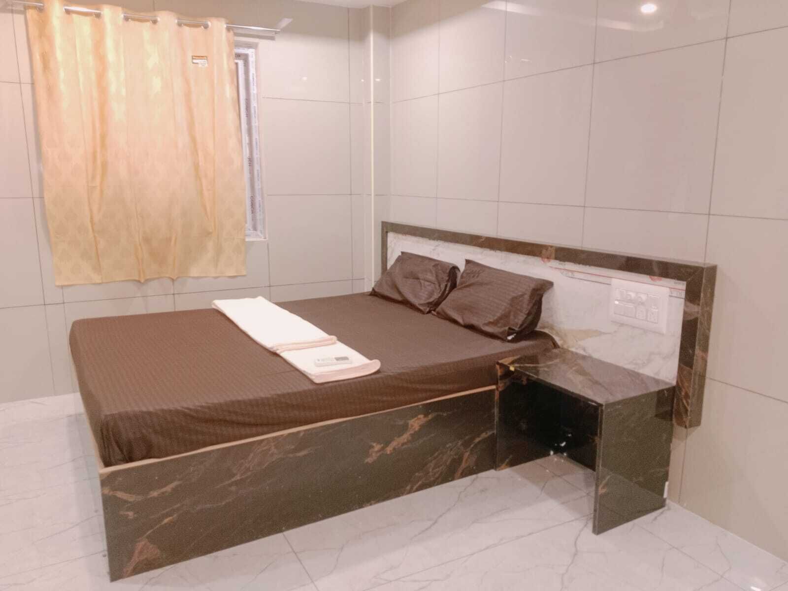 Un dormitorio moderno con cama, mesita de noche y espejo.
