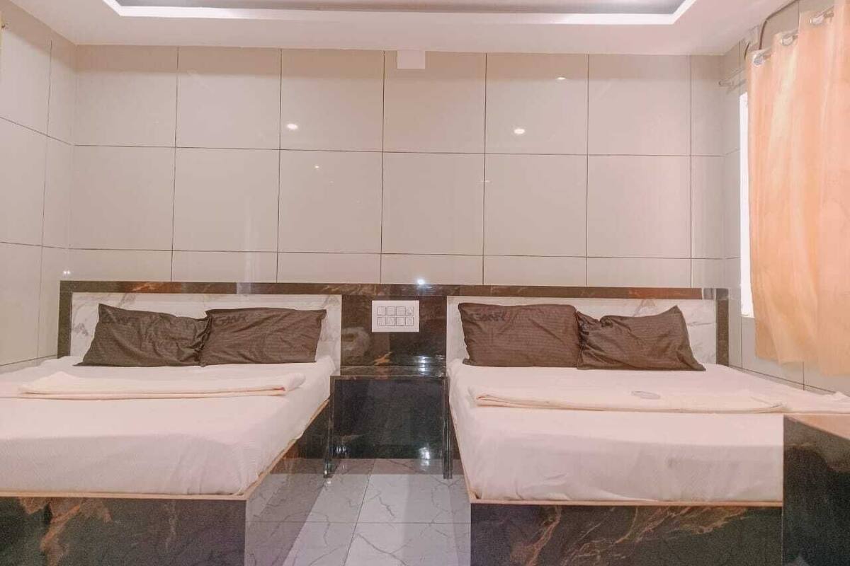 A hotel room with two beds, a marble floor, and a ceiling light.